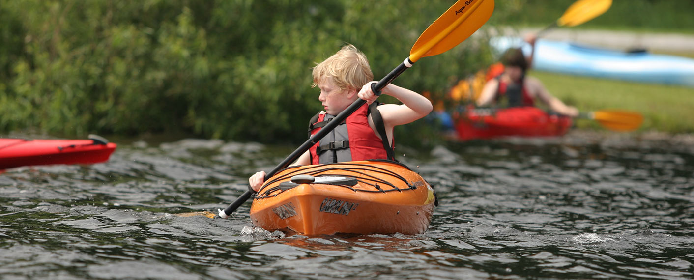 young boy in an orange kayak